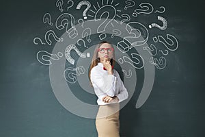 Businesswoman and question mark on blackboard