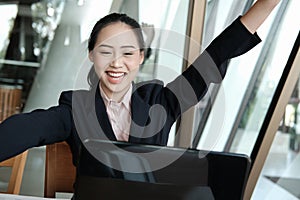 Businesswoman raise hand with happiness for successful project.