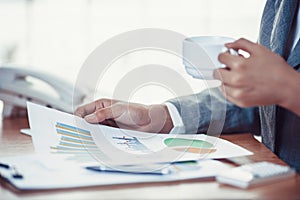 Businesswoman reading business chart on her desk