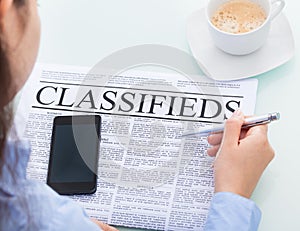 Businesswoman reading classifieds