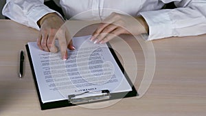 Businesswoman Reading Contract Paper At Desk