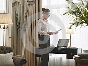 Businesswoman Reading Document In Home Office