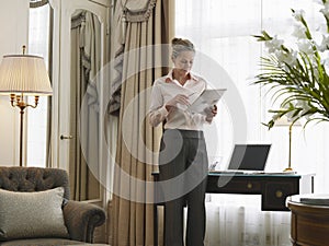 Businesswoman Reading Document In Home Office