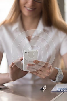 Businesswoman reading message on modern cellphone