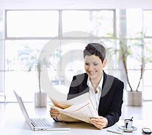 Businesswoman reading newspaper