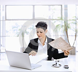 Businesswoman reading newspaper