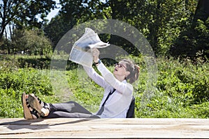 Businesswoman reading a newspaper in disbelief