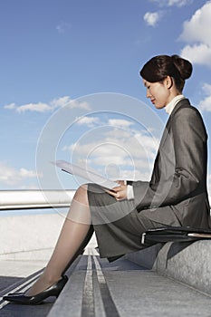 Businesswoman Reading Newspaper Outdoors