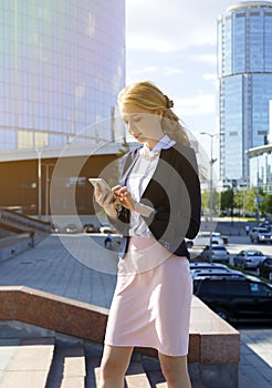 businesswoman receiving bad news in message. Business lady walking street during break. Woman chatting, reading sms on smartphone