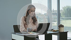 Businesswoman receiving bad news. Serious freelance woman working on laptop.