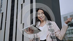 Businesswoman receiving good news on tablet. Winner girl celebrating victory