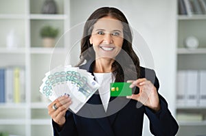 Businesswoman recommends credit card, holds a lot of money cash