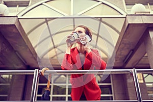 Businesswoman in red costume using mobile phone near office, girl browsing phone, female manager texting smartphone near