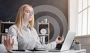 Businesswoman relaxing and meditating at workplace