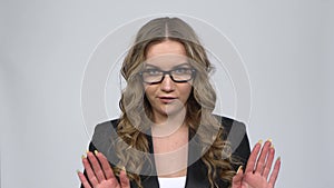 Businesswoman is reporting and tells a lot of interesting news against grey background