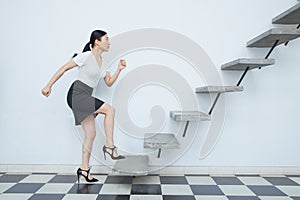 Businesswoman running up to stair.