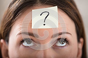 Businesswoman`s Forehead With Question Mark On Sticky Note