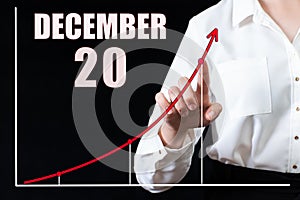 Businesswoman's hand pointing to the graph and a calendar with the date of 20 december. Business goals for the day.