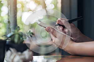 A businesswoman`s hand working and holding a white blank notebook with screwed up papers on table