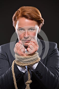 Businesswoman's hands tied up with rope