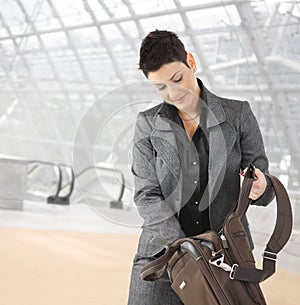 Businesswoman searching in laptop bag