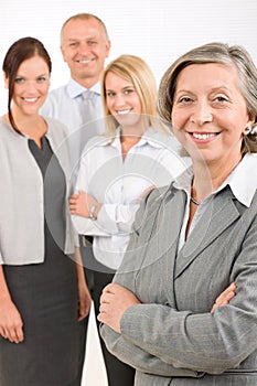 Businesswoman senior with colleagues in the back