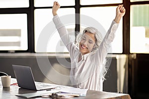 Businesswoman Shaking Fists At Laptop Celebrating Business Success In Offce