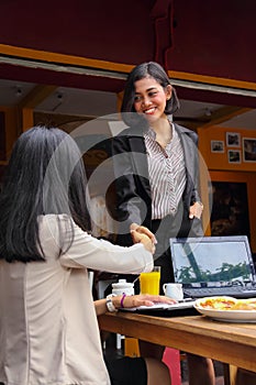 Businesswoman is shaking hands as she meets up with her business acquaintance