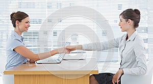 Businesswoman shaking hands with interviewee