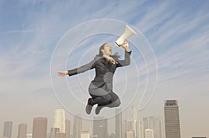 Businesswoman Shouting Into Megaphone Above City