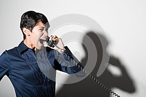 A businesswoman shouting on the telephone
