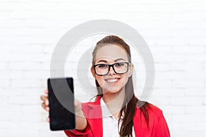 Businesswoman show cell smart phone screen with empty copy space wear red jacket glasses happy smile