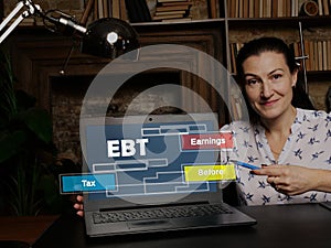 Businesswoman showing laptop with acronym  EBT Earnings Before Tax on the screen