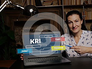 Businesswoman showing laptop with acronym  KRI Kairi Relative Index on the screen