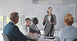Businesswoman showing results to group of business people at meeting