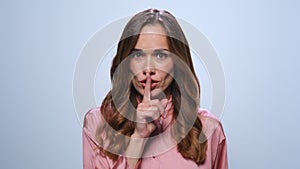 Businesswoman showing silence sign. Lady keeping secret with finger on lips