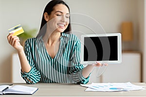 Businesswoman Showing Tablet Blank Screen Holding Credit Card In Office