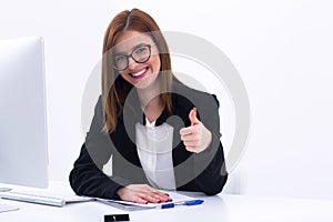 Businesswoman showing thumbs up at her workplace