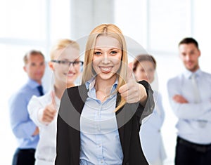 Businesswoman showing thumbs up in office