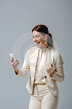 Businesswoman showing yeah gesture while holding
