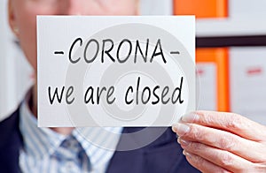 Businesswoman with sign, Corona, we are closed