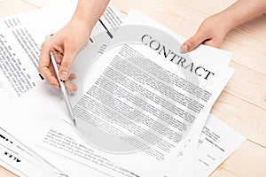 Businesswoman signing contract documents sitting at table