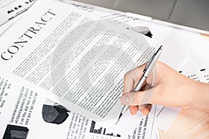 Businesswoman signing contract documents sitting at table