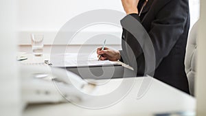 Businesswoman signing documents in a folder