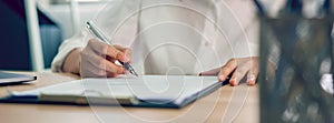 Businesswoman signing financial contract and hand holding pen putting signature after reaching agreement.