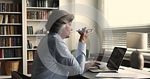 Businesswoman sit at desk holds smartphone talks on speakerphone