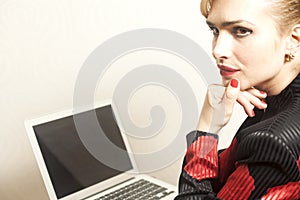 Businesswoman sits on chair with her laptop on wallpaper background