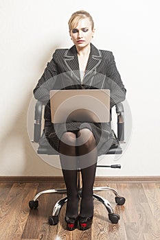 Businesswoman sits on chair with her laptop