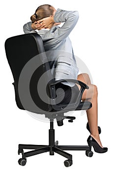 Businesswoman sitting back in chair with hands