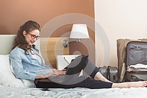 Businesswoman working in hotel room, using laptop.